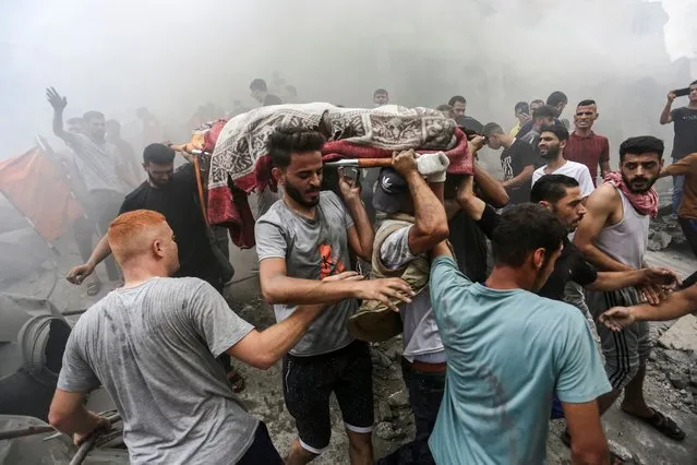 People carry the body of a Palestinian killed in Israeli strikes, in Jabalia refugee camp, in the northern Gaza Strip on October 9, 2023. (Photo by Mahmoud Issa/Reuters)
