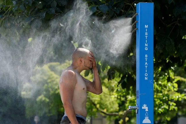A man cools off at a misting station during the scorching weather of a heatwave in Vancouver, British Columbia, Canada on June 27, 2021. (Photo by Jennifer Gauthier/Reuters)