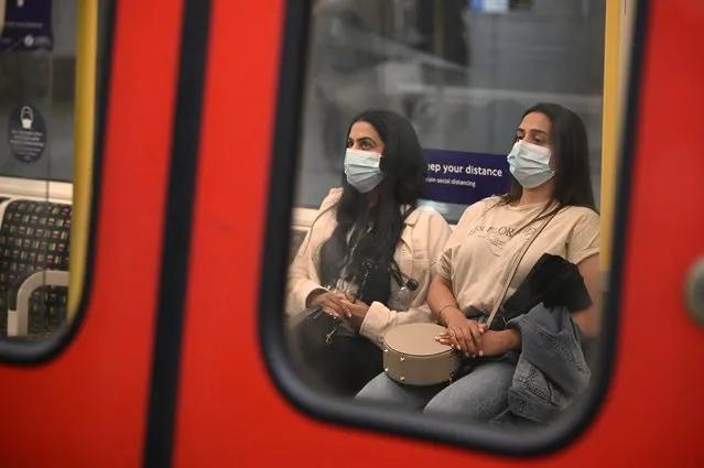 Commuters wearing protective face coverings to combat the spread of the coronavirus, travel on a Transport for London (TFL) Underground train in central London on July 5, 2021. British Prime Minister Boris Johnson on Monday unveils plans to lift most of the latest health restrictions from 19 July, including the mandatory wearing of face coverings on some forms of public transport. (Photo by Daniel Leal-Olivas/AFP Photo)