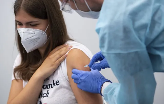 A student of a graduating class is vaccinated at the vaccination center at Messe Munich, Germany, Monday, July 12, 2021. (Photo by Sven Hoppe/dpa via AP Photo)