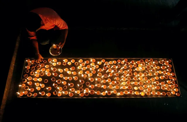A Tamil devotee lights oil lamps at a religious ceremony during the Diwali or Deepavali festival at Ponnambalavaneshwaram Hindu temple in Colombo, Sri Lanka October 29, 2016. (Photo by Dinuka Liyanawatte/Reuters)