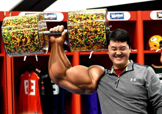 A fan poses with Skittle candy weights at the NFL Experience on February 6, 2016 in San Francisco, a day before the Carolina Panthers and the Denver Broncos play Super Bowl 50. (Photo by Timothy A. Clary/AFP Photo)