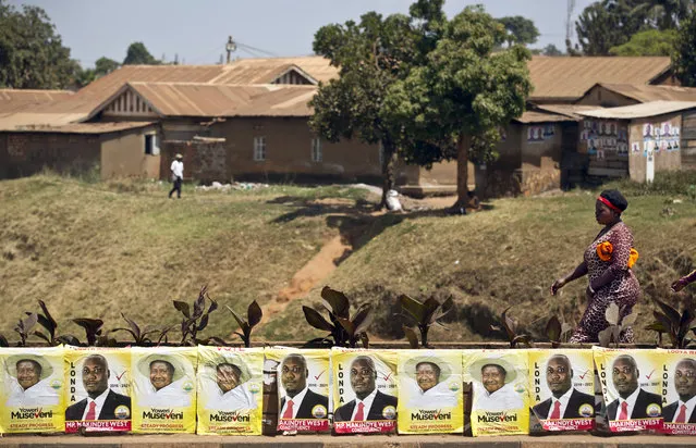 Pedestrians walk past campaign posters for long-time President Yoweri Museveni, as well as for local members of Parliament, on a street in Kampala, Uganda Wednesday, February 17, 2016. (Photo by Ben Curtis/AP Photo)