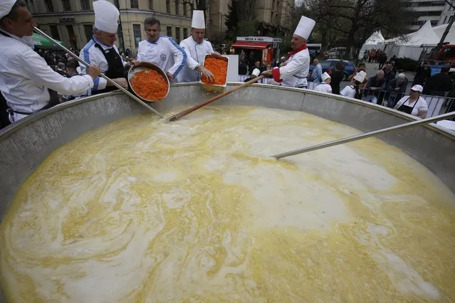 Bosnian cooks and volunteers prepare a chicken stew in Sarajevo, on Friday April 17, 2015. Bosnian chefs hope they have broken a Guinness record for the biggest chicken stew in the world, cooking up a meal for 14,000 people. The pot was set up in the center of Sarajevo and once the cooking was over the food was served to hundreds of people who gathered to watch the spectacle. (Photo by Amel Emric/AP Photo)