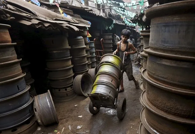 A boy pushes a trolley with used brake drums at a second-hand automobile parts market in Kolkata, India, February 23, 2016. (Photo by Rupak De Chowdhuri/Reuters)