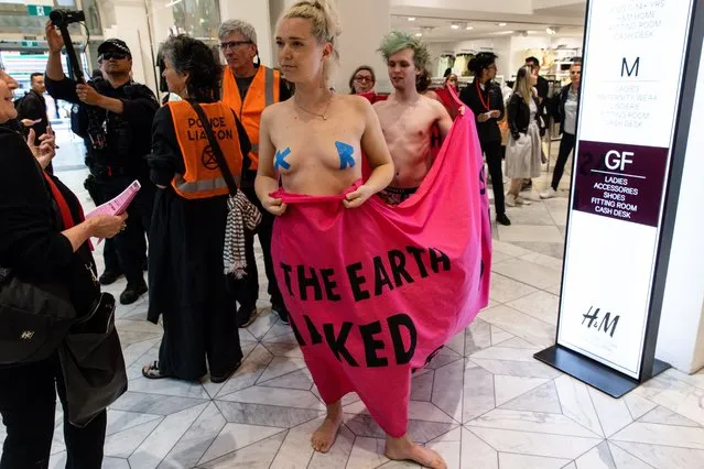 Activists wrapped with a banner stage a demonstration at an H&M store during an Extinction Rebellion protest at Bourke St Mall in Melbourne on Friday, November 25, 2022. (Photo by Diego Fedele/AAP Image)
