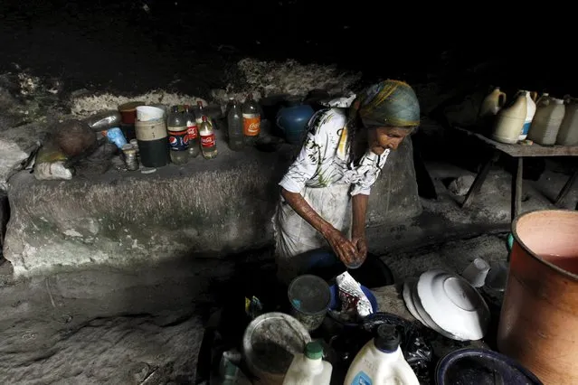 Francisca Gomez washes dishes inside her home, a cave where she has been living for the past 50 years, in the mountains on the outskirts of Chusmuy April 21, 2015. (Photo by Jorge Cabrera/Reuters)