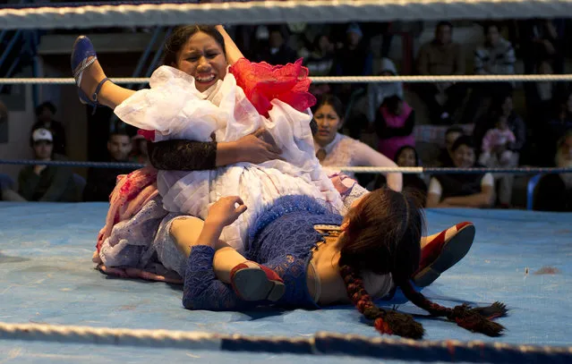Young cholita wrestler Dona Chevas, 16, top, holds the legs of her rival, fellow trainee Simpatica Sonia, 24, as they compete in the ring in El Alto, Bolivia, Thursday, January 21, 2019. A new generation of athletes is coming to one of the world's more colorful sporting spectacles: the fighting cholitas of Bolivia, who take to a wrestling ring in the traditional billowing skirts, bowler hats and leather shoes of Aymara women. (Photo by Juan Karita/AP Photo)