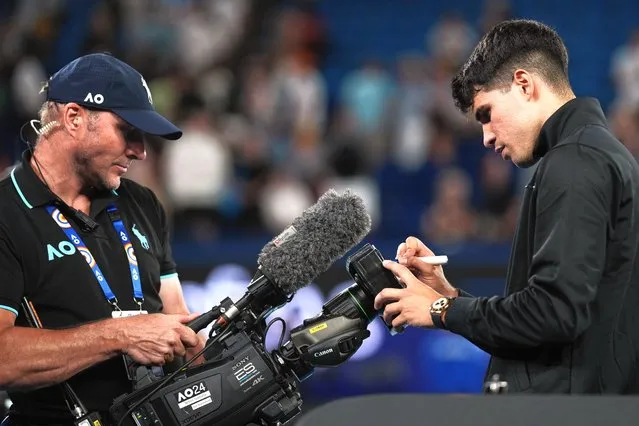 Carlos Alcaraz of Spain signs his autograph on a tv camera after defeating Richard Gasquet of France in their first round match at the Australian Open tennis championships at Melbourne Park, Melbourne, Australia, Tuesday, January 16, 2024. (Photo by Louise Delmotte/AP Photo)