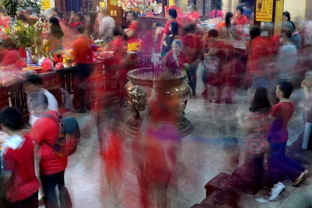 Members of the Chinese community offer prayers inside the Seng Guan temple during Chinese Lunar New Year celebrations in Manila's Chinatown, Philippines January 28, 2017. Picture taken with slow shutter speed. (Photo by Ezra Acayan/Reuters)