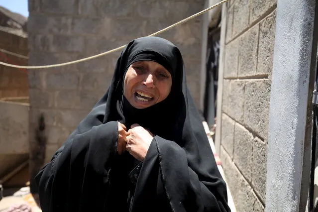 A woman cries after her home was damaged by a shell which landed from a nearby missile base after the base was struck by a Saudi-led coalition air strike, near Sanaa, April 23, 2015. (Photo by Mohamed al-Sayaghi/Reuters)