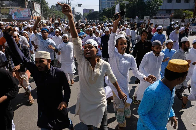 Muslim devotees shout slogans during a protest over an alleged insult to Islam, after Friday prayers outside the country’s main Baitul Mukarram Mosque in Dhaka, Bangladesh, Friday, October 15, 2021. Friday’s chaos in Dhaka followed reported incidents of vandalism of Hindu temples in parts of the Muslim-majority Bangladesh after photographs of a copy of the Holy book Quran at the feet of of a Hindu Goddess went viral on social media in a temple at Cumilla district in eastern Bangladesh. (Photo by Mahmud Hossain Opu/AP Photo)