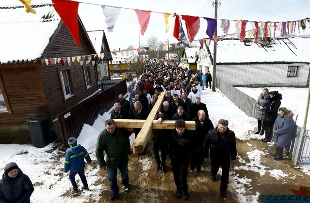 Belarussian Catholics carry a wooden cross as they take part in a procession celebrating Palm Sunday in the town of Oshmiany, Belarus, March 20, 2016. Catholic believers mark Palm Sunday on March 20 and will celebrate Easter the following Sunday. (Photo by Vasily Fedosenko/Reuters)
