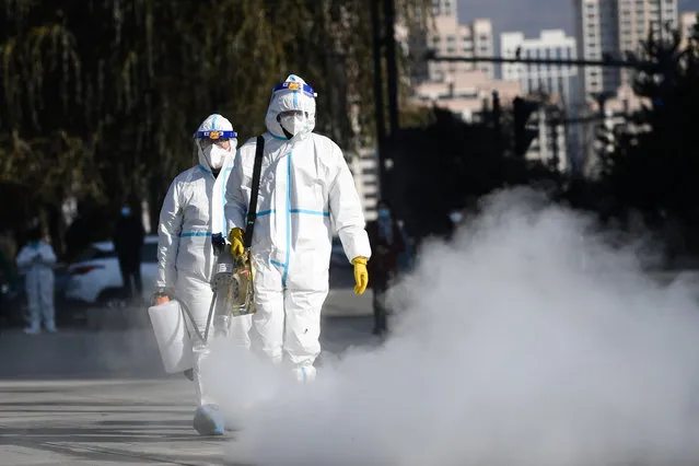Staff members spray disinfectant at a testing site in Chengxi District of Xining, northwest China's Qinghai Province, November 8, 2021. Xining started its second round of mass nucleic acid testing at 9 a.m. on Monday. As of November 7, Xining finished the first round of testing, and all swab samples from 1,448,000 citizens came back negative. (Photo by Xinhua News Agency/Rex Features/Shutterstock)