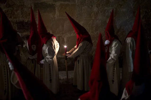 Penitents hold their candles as they take part in the “Procesion del Silencio” brotherhood, during the Holy Week in Zamora, Spain, Wednesday, March 23, 2016. (Photo by Emilio Morenatti/AP Photo)