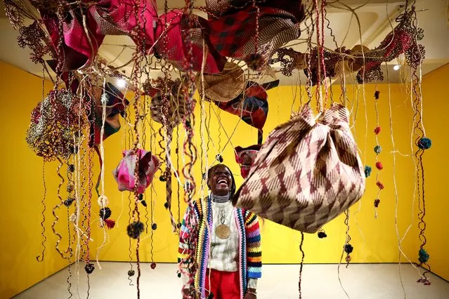 Uganda's artist Acaye Kerunen Ayelele looks at her piece “2023 Raffia” during a press preview ahead of the exhibition “Unravel: The Power and Politics of Textiles in Art” at the Barbican in central London on February 12, 2024. The exhibition is set to run from February 13 until May 26, 2024. (Photo by Henry Nicholls/AFP Photo)