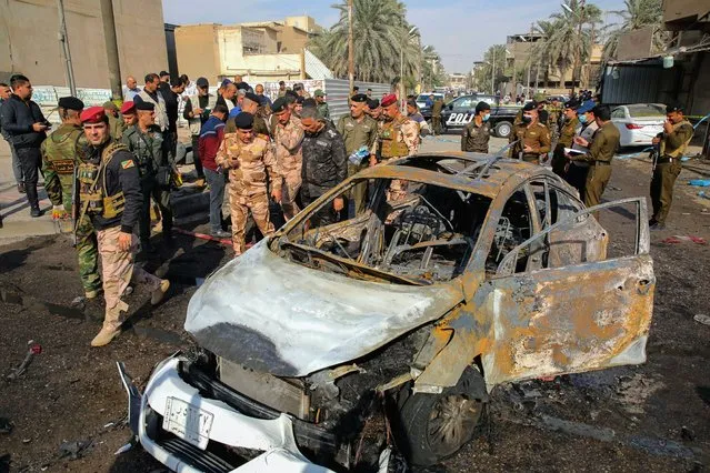 Iraqi security forces inspect the site of an explosion in Basra, Iraq, Tuesday, December 7, 2021. The explosion rocked the center of Iraq’s southern city of Basra, killing at least four people and wounding several others. Local news reports initially reported a car bomb, but the governor of Basra told reporters on the scene that a motorcycle had exploded. (Photo by Nabil al-Jurani/AP Photo)