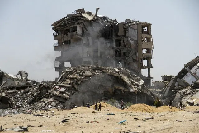 Palestinians walk past the rubble of residential buildings destroyed by Israeli strikes, amid the ongoing conflict between Israel and Hamas, in the northern Gaza Strip, on April 22, 2024. (Photo by Mahmoud Issa/Reuters)