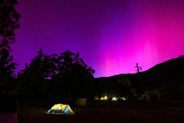 Northern lights or aurora borealis illuminate the night sky over a camper's tent north of San Francisco in Middletown, California on May 11, 2024. (Photo by Josh Edelson/AFP Photo)