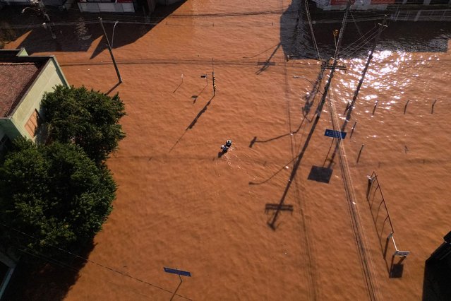Aerial view of flooded streets during rescue operations in the Sao Jao neighborhood of Porto Alegre, Brazil, taken on May 6, 2024, following torrential storms in southern Rio Grande do Sul state. The rains may have abated, but floodwaters on Monday continued their assault on southern Brazil, with hundreds of municipalities in ruins amid fears that food and drinking water may soon run out. Since the unprecedented deluge started last week, at least 83 people have died and 129,000 were ejected from their homes by floods and mudslides in Rio Grande do Sul state, authorities said. (Photo by Florian Plaucheur/AFP Photo)