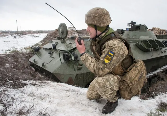 A Ukrainian soldier trains during military drills close to Kharkiv, Ukraine, Thursday, February 10, 2022. Britain's top diplomat has urged Russia to take the path of diplomacy even as thousands of Russian troops engaged in sweeping maneuvers in Belarus as part of a military buildup near Ukraine. (Photo by Andrew Marienko/AP Photo)