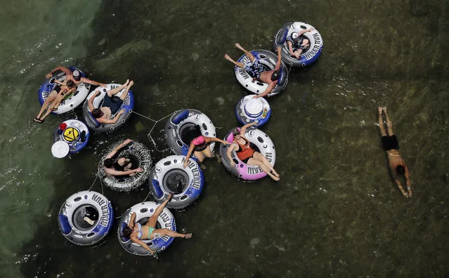 Tubers float on the Comal River, Wednesday, July 1, 2015, in New Braunfels, Texas. Both the Comal, with was closed briefly Tuesday due to weather, and Guadalupe river, which has been closed to tubers for several weeks, are scheduled to be open for water recreation for the holiday weekend. (Photo by Eric Gay/AP Photo)