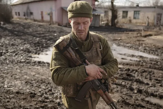 A Ukrainian serviceman walks near the frontline village of Krymske, Luhansk region, in eastern Ukraine, Saturday, February 19, 2022. Ukrainian President Volodymyr Zelenskyy, facing a sharp spike in violence in and around territory held by Russia-backed rebels and increasingly dire warnings that Russia plans to invade, on Saturday called for Russian President Vladimir Putin to meet him and seek resolution to the crisis. (Photo by Vadim Ghirda/AP Photo)