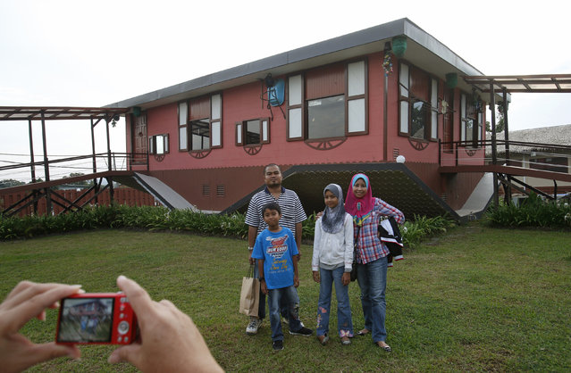 Tourists pose with an upside-down house in Tamparuli in Malaysia's state of Sabah on Borneo island September 17, 2012. Built for tourist attraction, the traditional Sabah village house was built with everyday households items like computer, refrigerator, sofa sets, dining table and beds – but all items are upside down. (Photo by Bazuki Muhammad/Reuters)