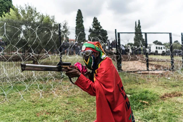An Economic Freedom Fighters supporter shows a mock weapons during a demonstration in Pretoria on April 12, 2017 calling for South African President Jacob Zuma to resign. Tens of thousand demonstrators took part in the march to Union Buildings, the official seat of government, which was organised on Zuma's 75th birthday and came after nationwide rallies against the president last week. Zuma's recent sacking of respected finance minister Pravin Gordhan has fanned years of public anger over government corruption scandals, record unemployment and slowing economic growth. (Photo by Marco Longari/AFP Photo)