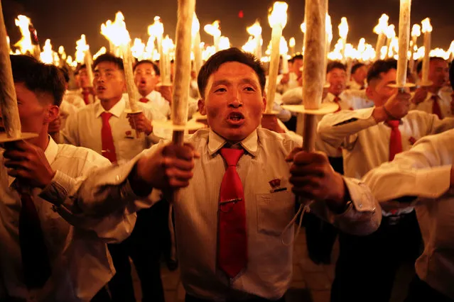 Participants carry torches during a torchlight procession in the capital's main ceremonial square, a day after the ruling Workers' Party of Korea party wrapped up its first congress in 36 years, in Pyongyang, North Korea, May 10, 2016. (Photo by Damir Sagolj/Reuters)