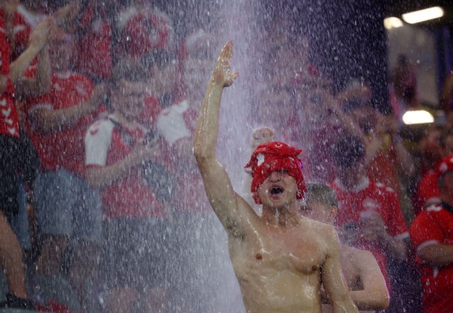 A Denmark fan stands under water pouring from the roof into the stadium after referee Michael Oliver stopped the game due to adverse weather conditions at Euro 2024 in Dortmund, Germany, on June 29, 2024. (Photo by Thilo Schmuelgen/Reuters)