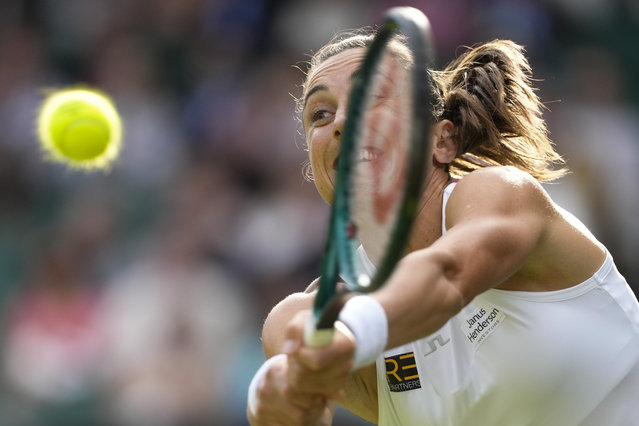 Petra Martic of Croatia plays a backhand return to to Iga Swiatek of Poland during their second round match at the Wimbledon tennis championships in London, Thursday, July 4, 2024. (Photo by Kirsty Wigglesworth/AP Photo)