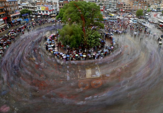 A picture taken with a slow shutter speed shows Nepalese devotees taking a round circle while pulling a 32 feet giant wooden chariot during celebrations of the Rato Machhindranath or Rain god festival in Lalitpur, near Kathamandu, Nepal, 17 May 2016. Bajracharya's feet aren't allowed to touch the ground as Kumari or Living Goddess. The Hindus and Buddhists of the Newar community in Patan celebrate the Ratomachindranath festival by pulling a 32-feet high wooden chariot all over the valley for a month. The festival is celebrated in the hope of a good harvest, prosperity and good luck, for coming year. (Photo by Narendra Shrestha/EPA)