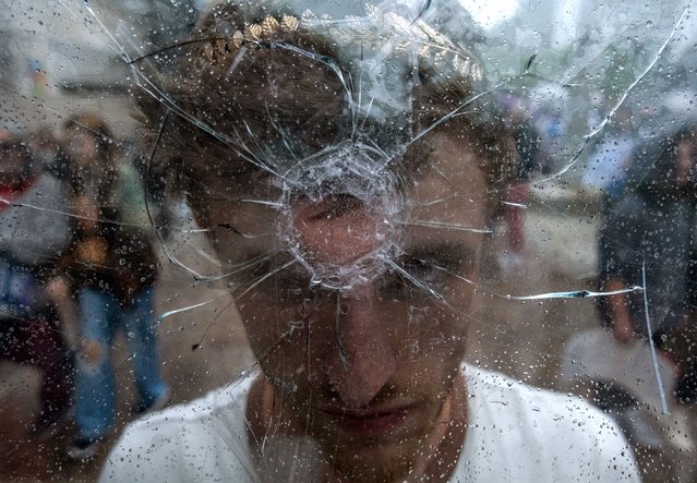 A protester holds a shattered window mimicking a gun shot to his forehead as students from across Nashville walked out of schools and gather at the Tennessee State Capitol Building in protest to demand action for gun reform laws in the state on April 3, 2023 in Nashville, Tennessee. A 28-year-old former student of the private Covenant School in Nashville, wielding a handgun and two AR-style weapons, shot and killed three 9-year-old students and three adults before being killed by responding police officers on March 27th. (Photo by Seth Herald/Getty Images)