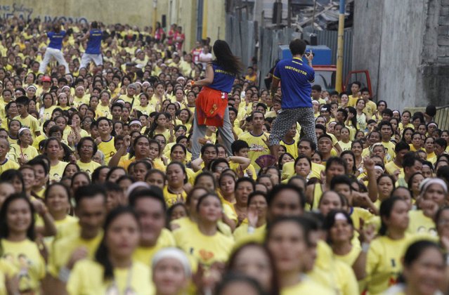 Thousands of health enthusiasts dance to high tempo music as they  participate in a Guinness World Records attempt for the largest Zumba class held along the main streets of Mandaluyong city, metro Manila, July 19, 2015. (Photo by /Lorgina MinguitoReuters)