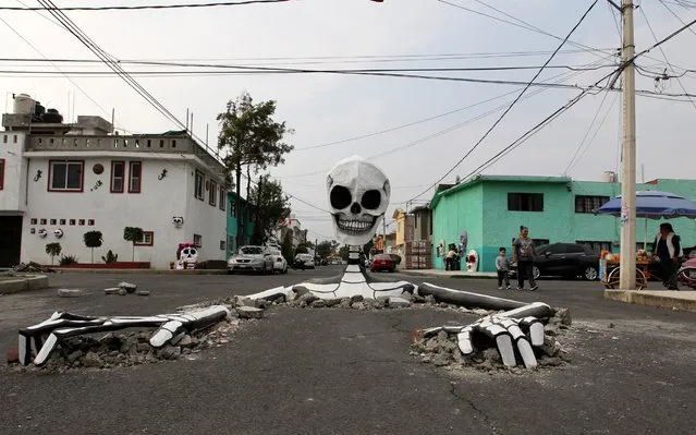 General view of a skeleton statue emerging from potholes in a street in the town of the municipality of Tlahuac, Mexico City, Mexico, 28 October 2019. The simulation of the potholes was recreated by Raymundo Medina, an inhabitant of this urban area of the Mexican capital, to commemorate the Day of the Dead and incidentally, take advantage of making a call to the authorities so that the streets of his town are fixed. (Photo by Mario Guzman/EPA/EFE/Rex Features/Shutterstock)