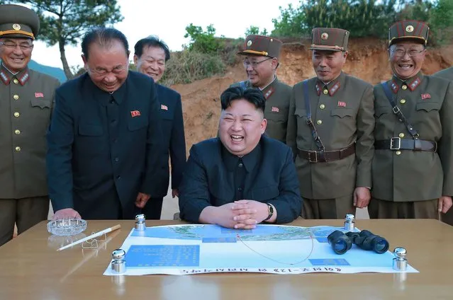 This picture taken on May 14, 2017 and released from North Korea's official Korean Central News Agency (KCNA) on May 15 shows North Korean leader Kim Jong-Un (C) reacting during a test launch of a ground-to-ground medium long-range strategic ballistic rocket Hwasong-12 at an undisclosed location. (Photo by AFP Photo/KCNA)