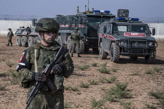 Turkish and Russian patrol is seen near the town of Darbasiyah, Syria, Friday, November 1, 2019. Turkey and Russia launched joint patrols Friday in northeastern Syria, under a deal that halted a Turkish offensive against Syrian Kurdish fighters who were forced to withdraw from the border area following Ankara's incursion. (Photo by Baderkhan Ahmad/AP Photo)