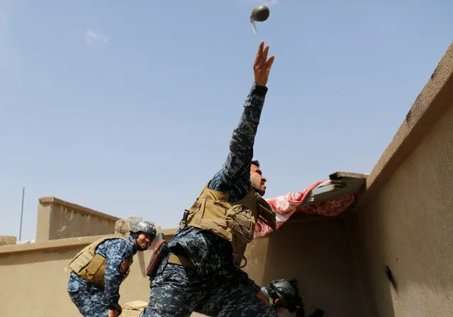 A members of the Iraqi Federal Police throws a hand grenade during clashes with the Islamic State fighters in western Mosul, Iraq on April 29, 2017. (Photo by Danish Siddiqui/Reuters)