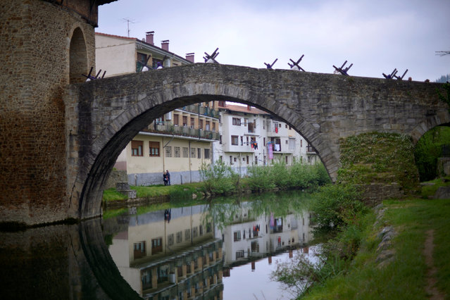 Locals carrying crosses walk across a bridge during a Via Crucis representation on Good Friday, in the Basque town of Balmaseda, northern Spain April 14, 2017. (Photo by Vincent West/Reuters)