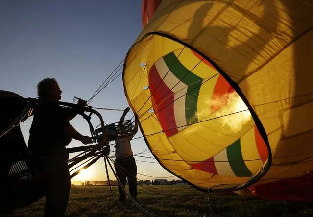 Crews inflate their hot air balloons in the early morning during the 33rd annual QuickChek New Jersey Festival of Ballooning at Solberg Airport Friday, July 24, 2015, in Readington, N.J. (Photo by Mel Evans/AP Photo)