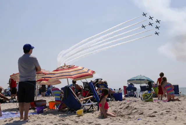 Spectators watch the Breitling Jet Team perform over Jones Beach during the 13th Annual Bethpage Air Show, Saturday, May 28, 2016, in Jones Beach, N.Y. (Photo by Julie Jacobson/AP Photo)