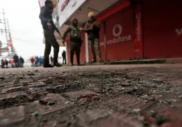 Indian policemen stand guard at the site of a grenade explosion in Srinagar, November 26, 2019. (Photo by Danish Ismail/Reuters)