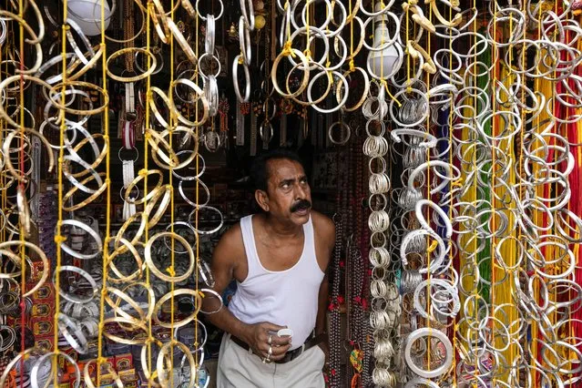 A shopkeeper waits for customers for bangles on sale at his shop on Bengali New Year's day in Kolkata, India, Friday, April 15, 2022. Traders in West Bengal open their new account books for the year on Bengali New Year after offering prayers to Lakshmi and Ganesha to bring them prosperity. (Photo by Bikas Das/AP Photo)