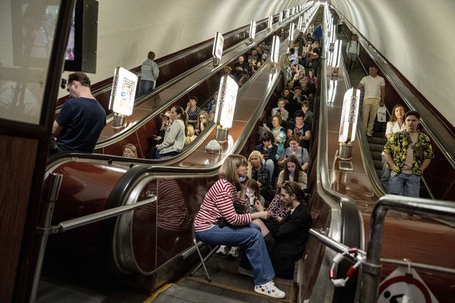 People take cover at metro station during a Russian rocket attack in Kyiv, Ukraine, Monday, May 29, 2023. Explosions have rattled Kyiv during daylight as Russian ballistic missiles fell on the Ukrainian capital. The barrage came hours after a more common nighttime attack of the city by drones and cruise missiles. (Photo by Evgeniy Maloletka/AP Photo)