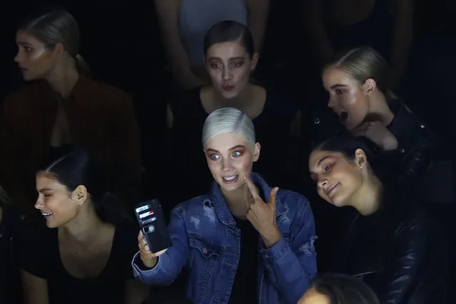 Models pose for selfies on a mobile phone as they wait for pre-show instructions during rehearsal ahead of The Innovators: Fashion Design Studio show during Mercedes-Benz Fashion Week Resort 17 Collections on May 20, 2016 in Sydney, Australia. (Photo by Mark Kolbe/Getty Images)