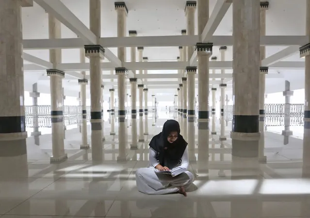 A Muslim woman reads Quran in a mosque on the third day of Ramadan in Jakarta, Indonesia, Monday, May 29, 2017. During Ramadan, the holiest month in Islamic calendar, Muslims refrain from eating, drinking, smoking and s*x from dawn to dusk. (Photo by Tatan Syuflana/AP Photo)
