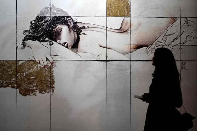 A visitor views a design by Italian cartoonist Milo Manara at the Fuorisalone 2022 design event on June 6, 2022 in Milan. (Photo by Miguel Medina/AFP Photo)