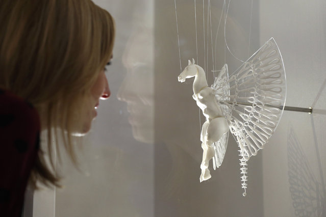 A woman admires a 3D printed artwork which is displayed in the exhibition “3D: printing the future” in the Science Museum on October 8, 2013 in London, England. The exhibition, which opens to the public tomorrow, features over 600 3D printed objects ranging from: replacement organs, artworks, aircraft parts and a handgun. (Photo by Oli Scarff/Getty Images)