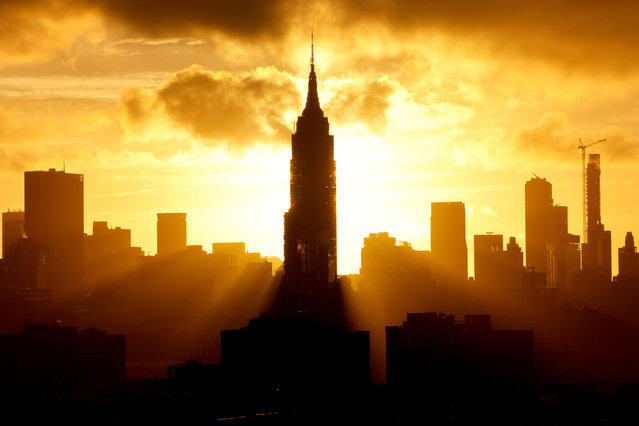 The sun rises behind the skyline of midtown Manhattan and the Empire State Building on the first full day of autumn in New York City on September 23, 2024, as seen from Jersey City, New Jersey. (Photo by Gary Hershorn/Getty Images)